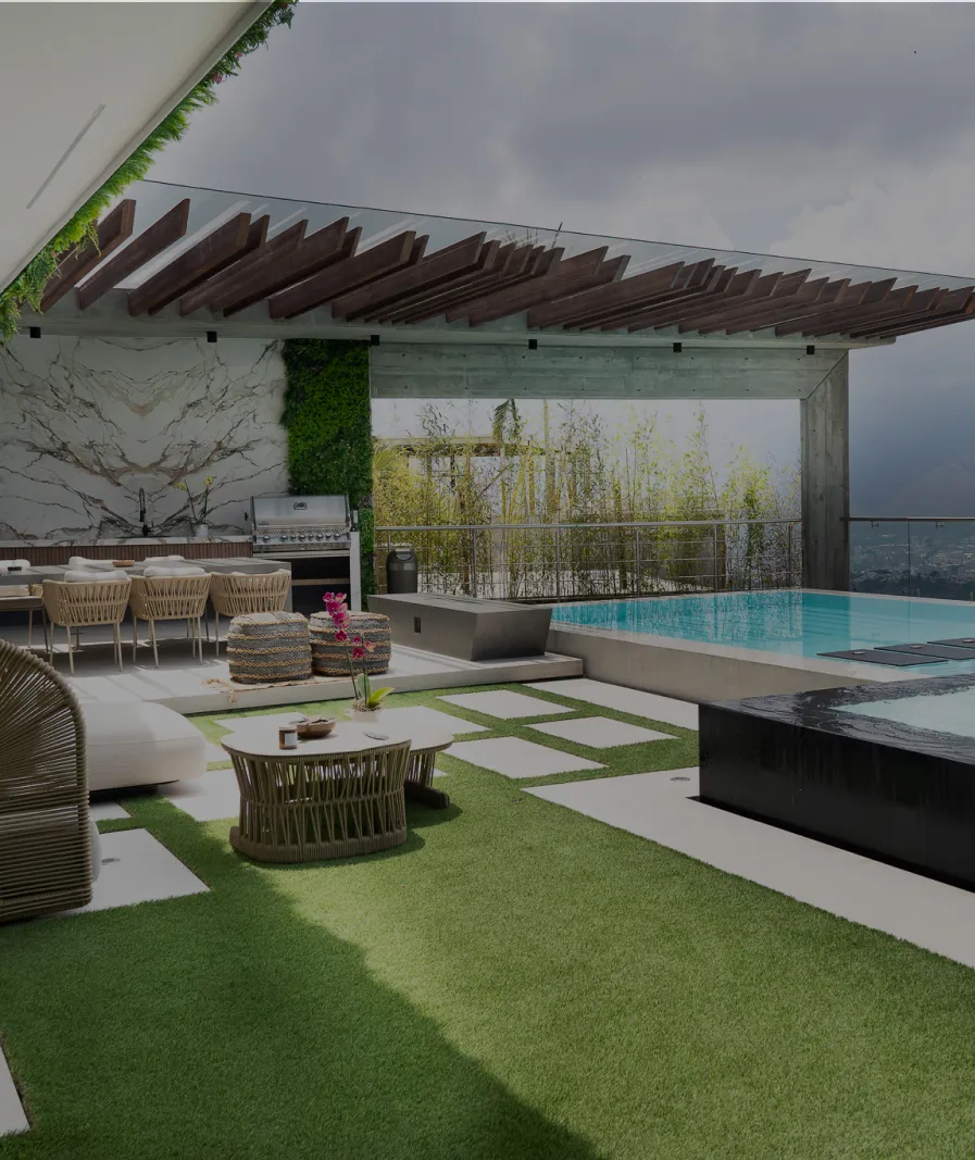 Outdoor entertaining area with stone surfaces beside a swimming pool