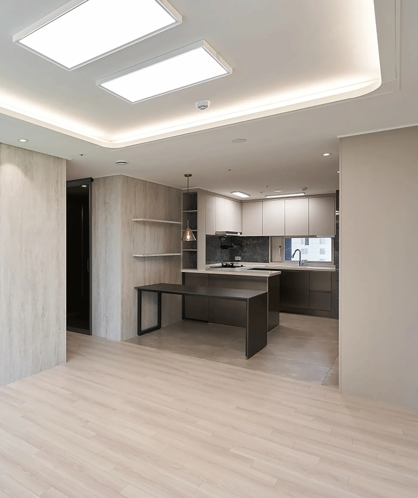 Open-plan interior with stone wall cladding and a dark kitchen