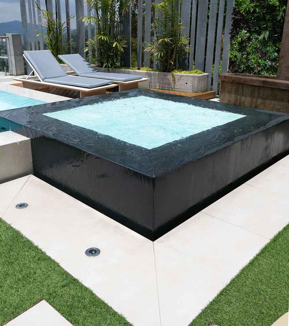 Dark stone spa surround in an outdoor pool area