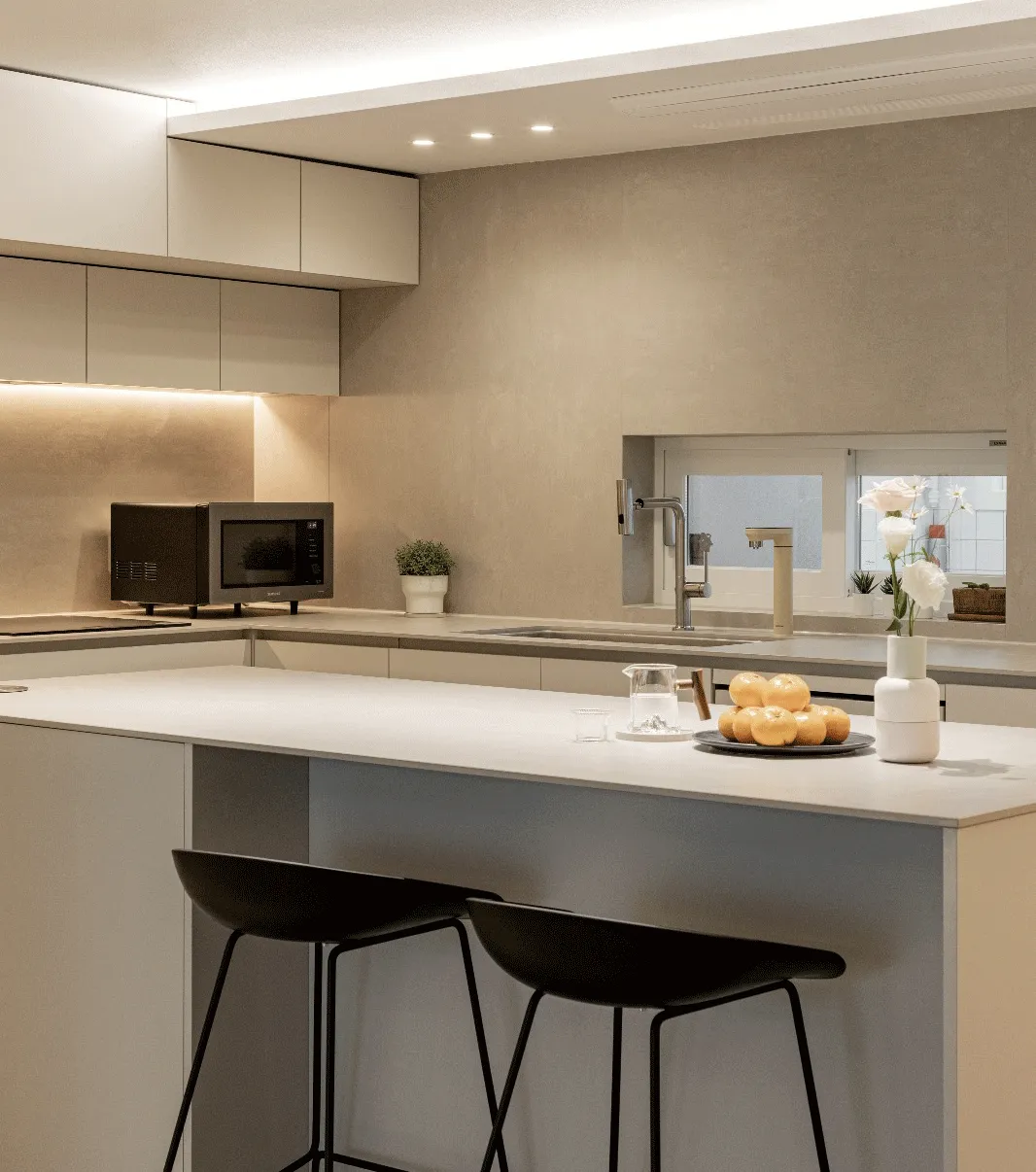 Neutral kitchen with a pale stone island and grey cabinetry