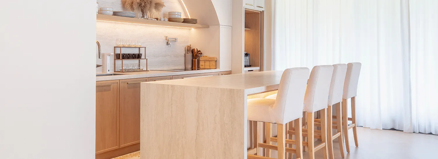 Warm residential kitchen featuring a Travertine White island and splashback