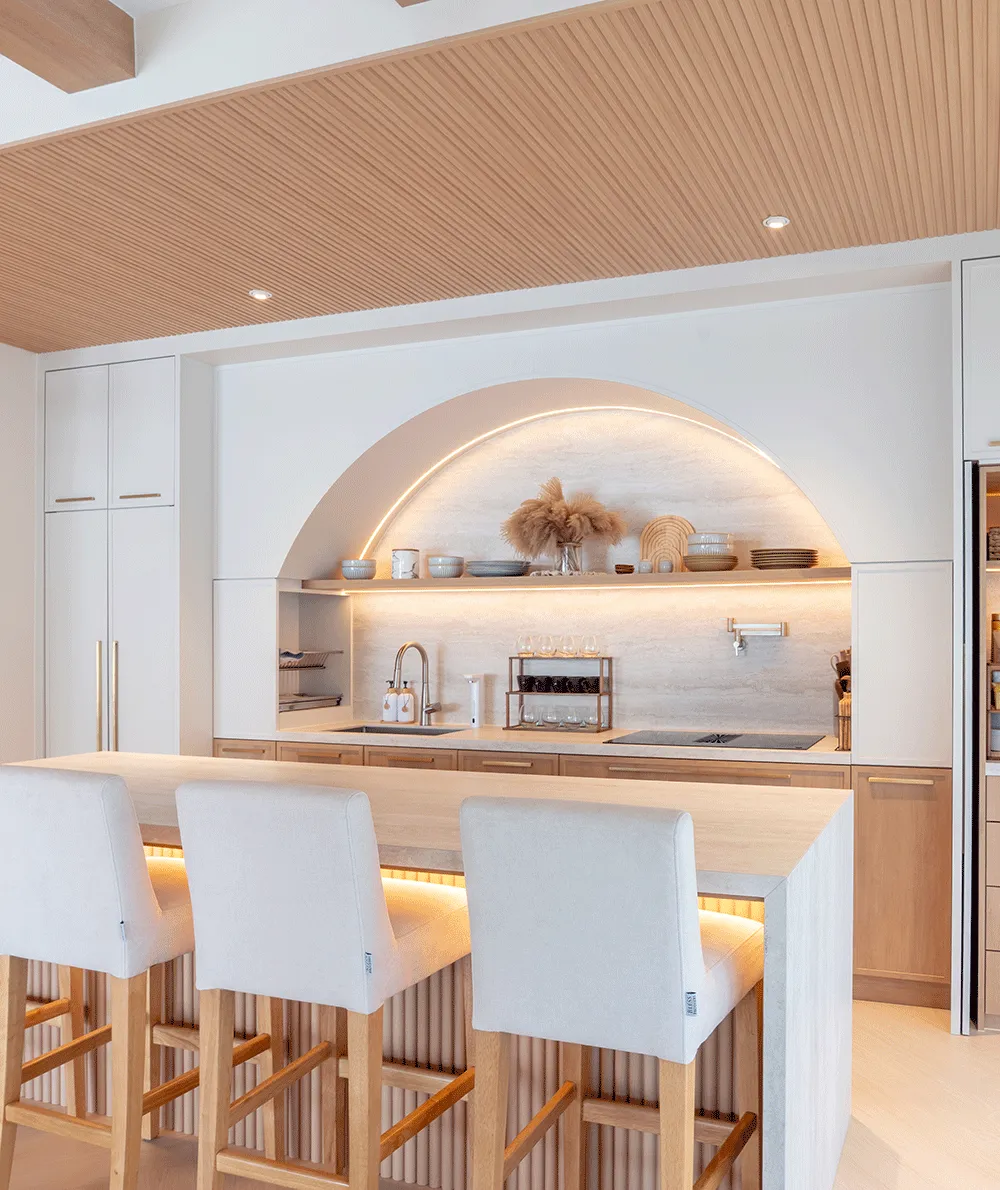 Travertine White kitchen with an arched splashback and waterfall island