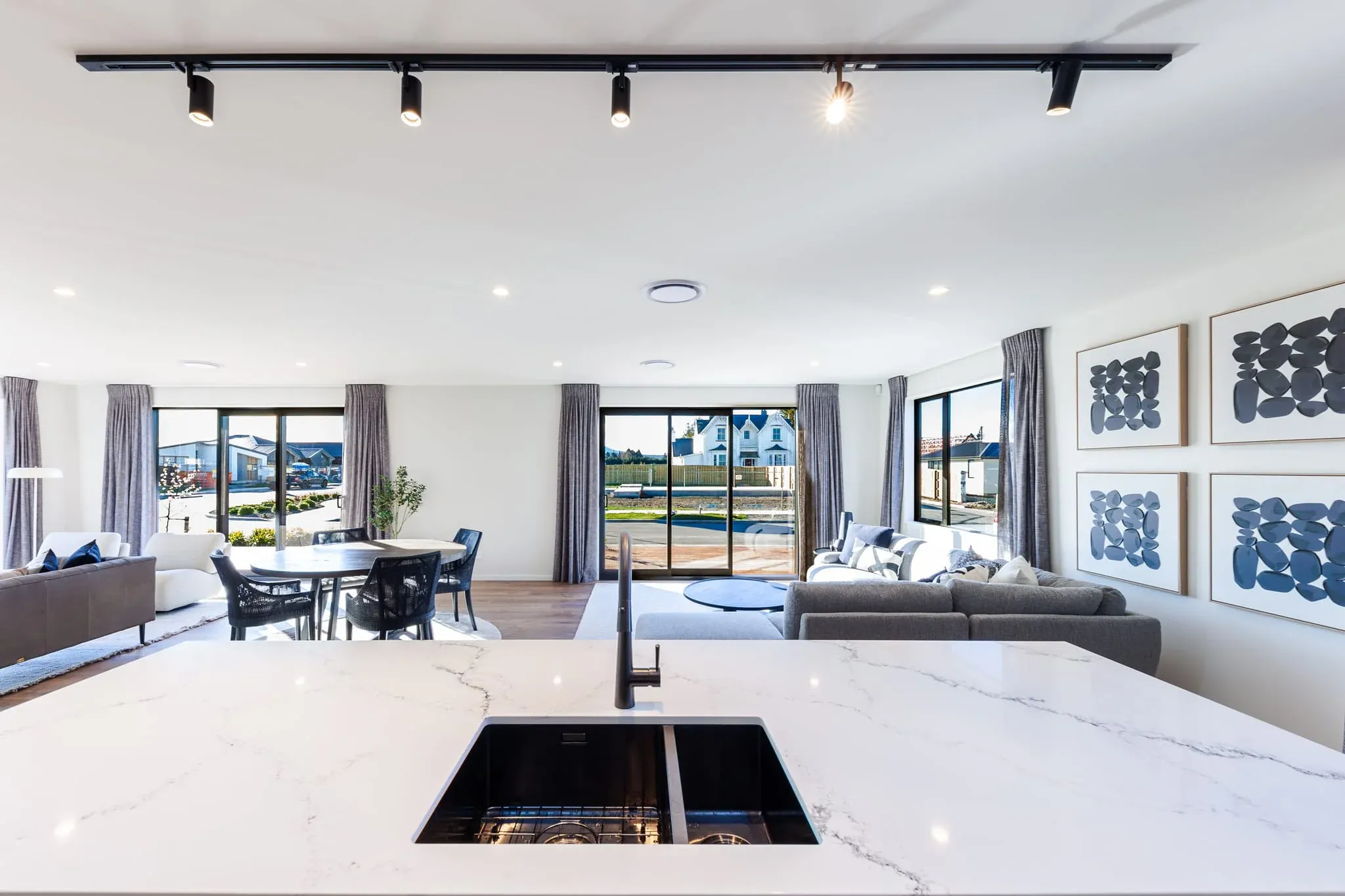 Open-plan Trendsetter Homes living area viewed across the Hellenic kitchen benchtop